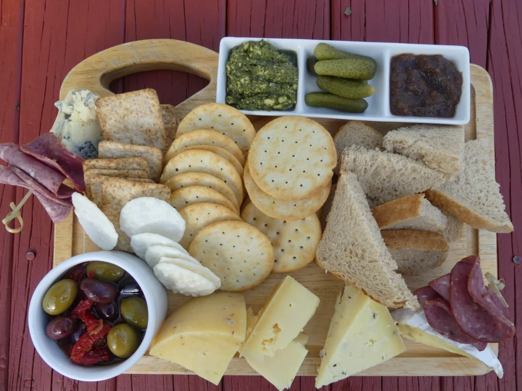 A large Cheese Barn cheese board with crackers, pickles and dips